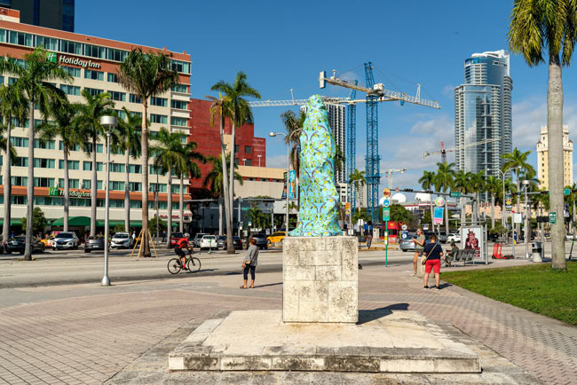 Joiri Minaya, The Cloaking of the statue of Ponce de Leon at the Torch of Friendship on Biscayne Blvd, Miami, Florida, 2019. dye-sublimation print on spandex fabric and wood scructure. Photos by Zachary Balber, commissioned by Fringe Projects Miami. Courtesy of the artist.